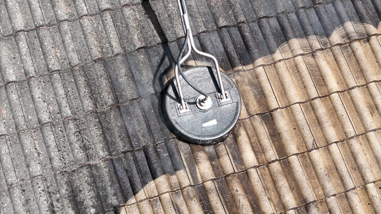 A round pressure washer nozzle is cleaning a dirty roof in Blue Mountains, showing a clear contrast between the cleaned and uncleaned sections.